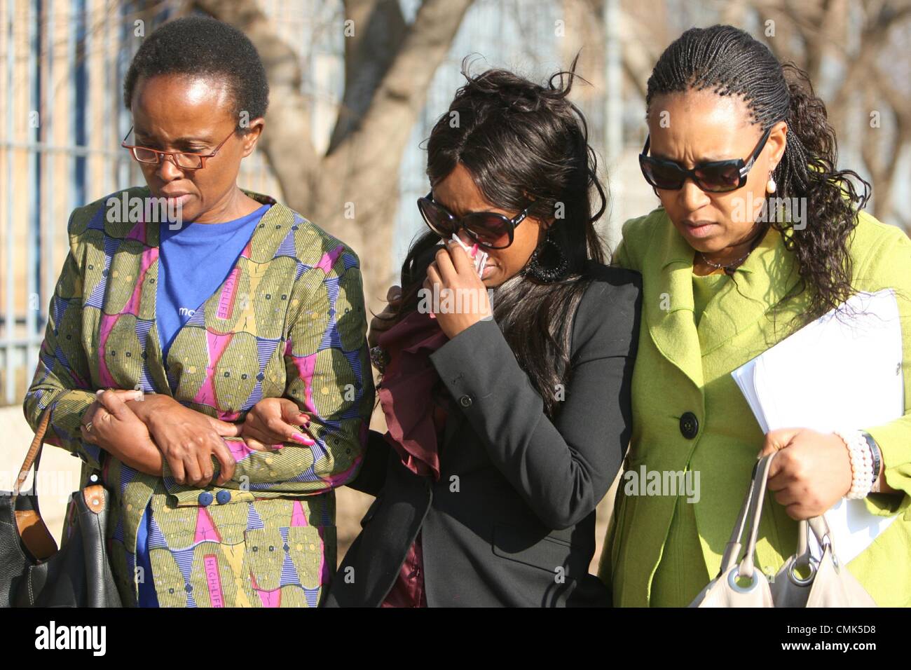 JOHANNESBURG, SOUTH AFRICA: Zenani Mandela (R) comforts her daughter Zoleka Mandela (C) outside the Johannesburg Magistrates Court on August 20, 2012 in Johannesburg, South Africa. They attended the trial of Sizwe Mankazana who is charged with murder, attempted murder and negligent driving after Nelson Mandela’s great-granddaughter Zenani Mandela was killed in a car crash. (Photo by Gallo Images / Sowetan / Mabuti Kali) Stock Photo