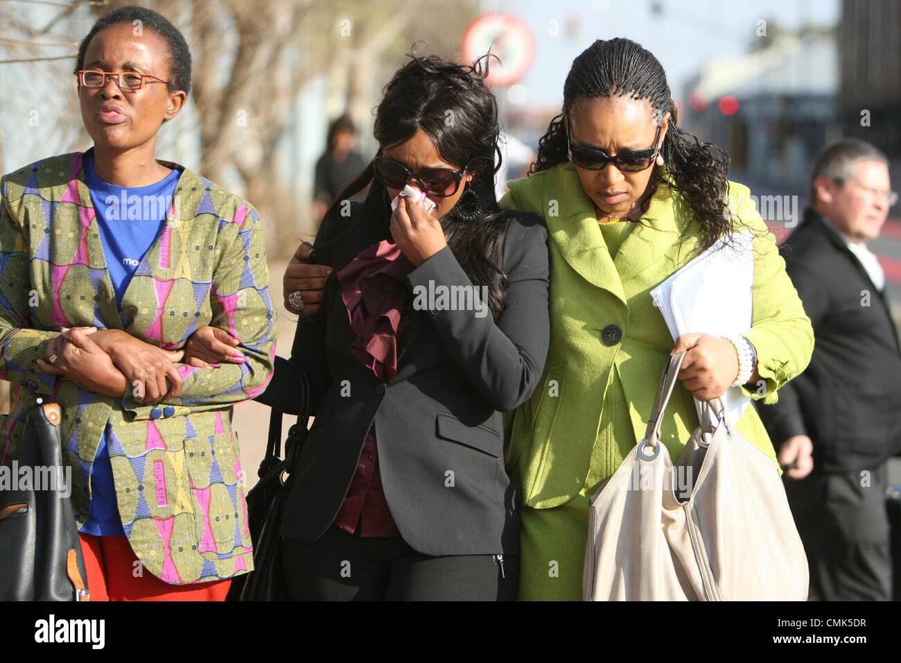 JOHANNESBURG, SOUTH AFRICA: Zenani Mandela (R) comforts her daughter Zoleka Mandela (C) outside the Johannesburg Magistrates Court on August 20, 2012 in Johannesburg, South Africa. They attended the trial of Sizwe Mankazana who is charged with murder, attempted murder and negligent driving after Nelson Mandela’s great-granddaughter Zenani Mandela was killed in a car crash. (Photo by Gallo Images / Sowetan / Mabuti Kali) Stock Photo