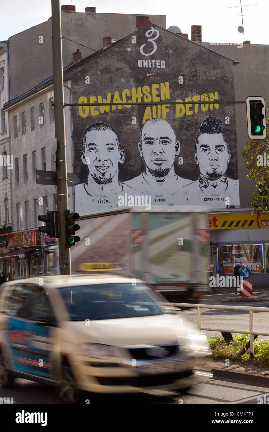 Berlin-Wedding, Germany. 30th Oct, 2013. A sporting good manufacturer advertises with the faces of the brothers Jerome (L-R), George and Kevin-Prince Boateng on the wall of a building in Berlin-Wedding, Germany, 30 October 2013. Schalke's pro soccer player Kevin-Prince Boateng supposedly learned how to play soccer in this cage. Photo: Joerg Carstensen/dpa/Alamy Live News Stock Photo