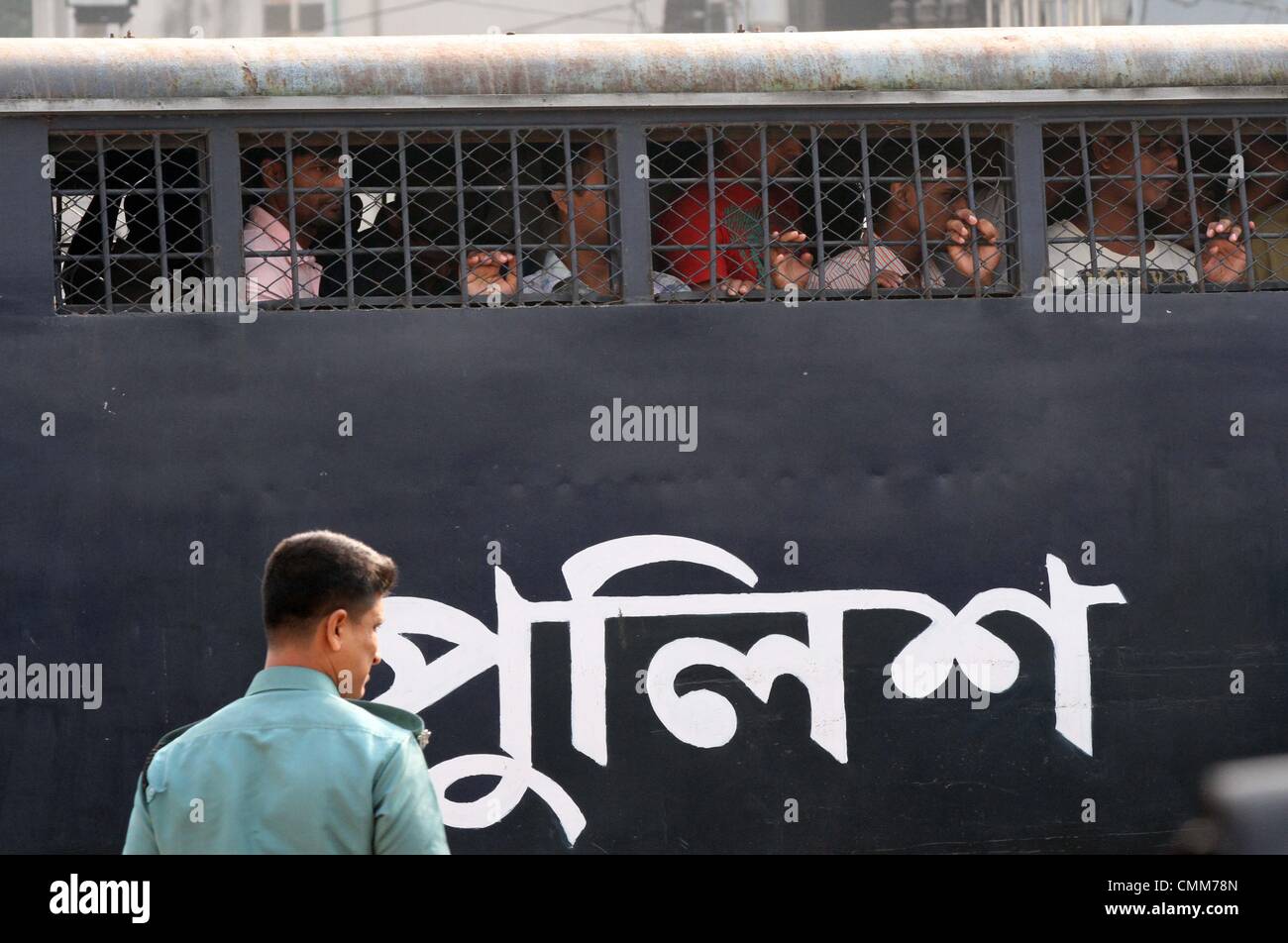 Dhaka, Bangladesh. 5th November 2013. Handcuffed Bangladesh Rifles (BDR) soldiers look through a prison van as they arrive at the special court in Dhaka on November 5, 2013. Some 800 Bangladeshi soldiers appeared in a huge specially-built court accused of murder and other serious offences during a bloody mutiny in 2009. During the uprising, which lasted about 30 hours, 74 people -including 57 senior army officers- were killed at a military base in the capital Dhaka.. Stock Photo