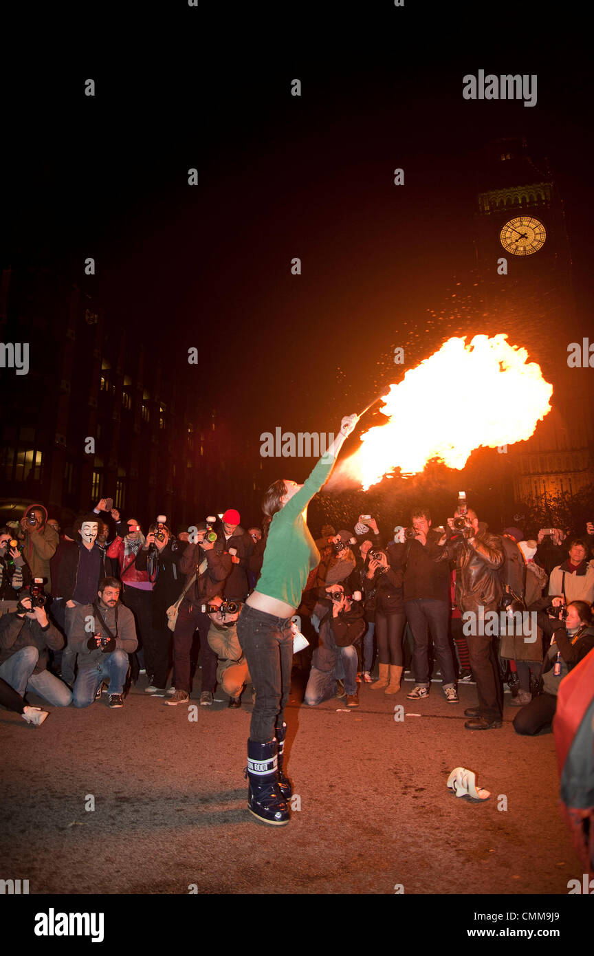 London, UK. 05/11/13. A fire breather blows flames towards Parliament, as over a 1000 activists from various anti-Austerity groups protest in Central London. 05/10/2013 Credit:  Pete Maclaine/Alamy Live News Stock Photo