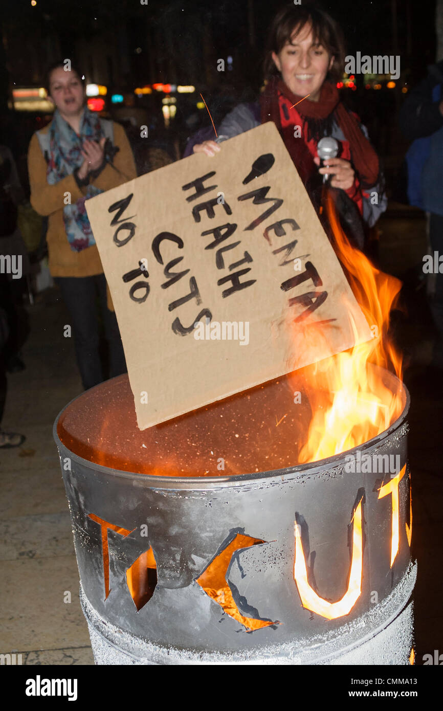 Bristol,UK.5th Nov, 2013. An Anti-austerity protester in Bristol is photographed burning a placard during the Bonfire of Austerity protest. Credit:  lynchpics/Alamy Live News Stock Photo
