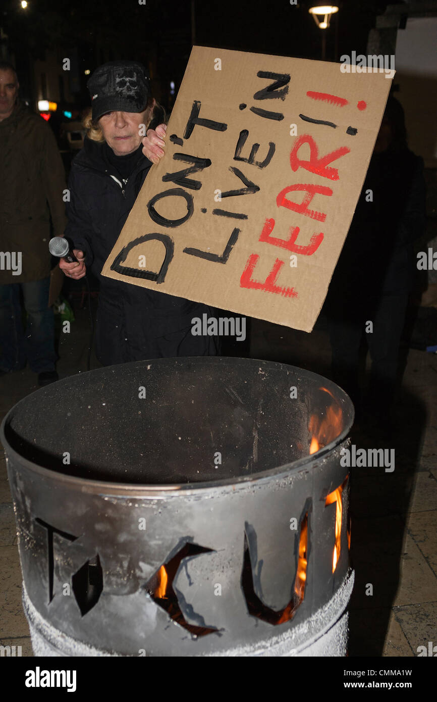 Bristol,UK.5th Nov, 2013. An Anti-austerity protester in Bristol is photographed burning a placard during the Bonfire of Austerity protest. Credit:  lynchpics/Alamy Live News Stock Photo