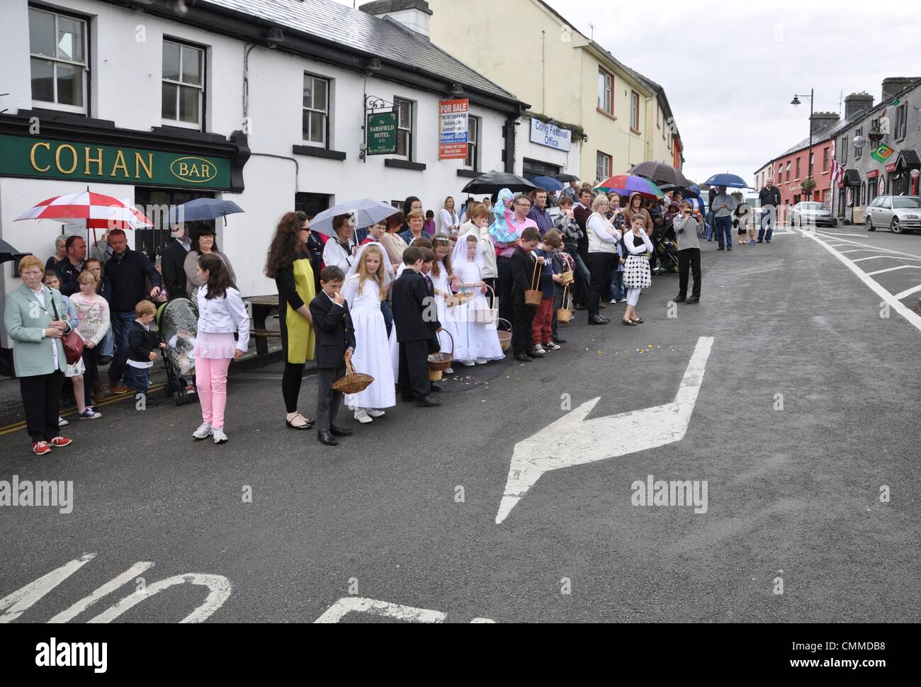 On a rainy Sunday first communicants stand on the market square of Cong ...