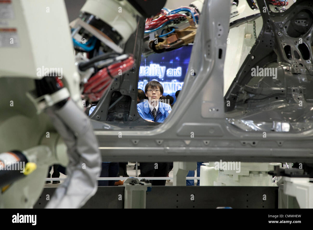 Tokyo, Japan. 6th Nov, 2013. A man sees the Kawazaki 'Body Assembly' system performance at the International Robot Exhibition 2013 in Tokyo, Japan, November 6, 2013. The IREX is the largest robot trade fair in the world and shows new robots and high technology equipments at theTokyo International Big Sight. The exhibitions runs from November 6 to 9. © Rodrigo Reyes Marin/AFLO/Alamy Live News Stock Photo
