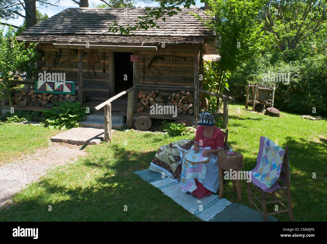 Tennessee, Norris, Museum of Appalachia, Mark Twain Family Cabin moved here from 'Possum Trot, Tenn., reenactor making quilt. Stock Photo