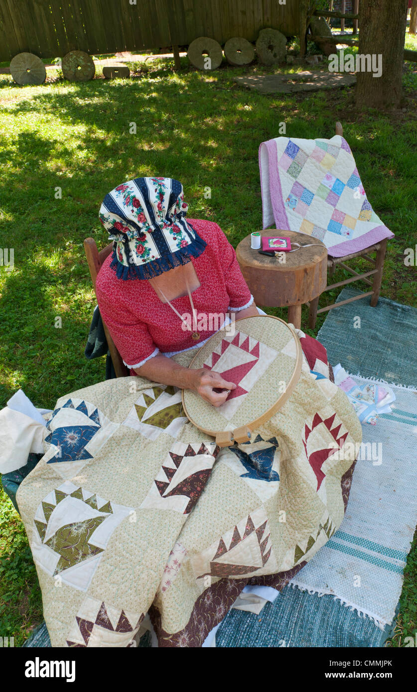 Tennessee, Norris, Museum of Appalachia, Mark Twain Family Cabin moved here from 'Possum Trot, Tenn., reenactor making quilt. Stock Photo