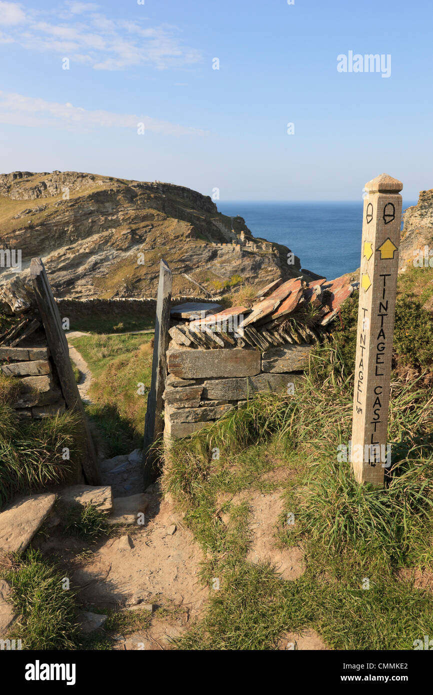 Path sign to King Arthur's Camelot Castle and stile through stone wall on the coast. Tintagel Cornwall England UK Britain Stock Photo