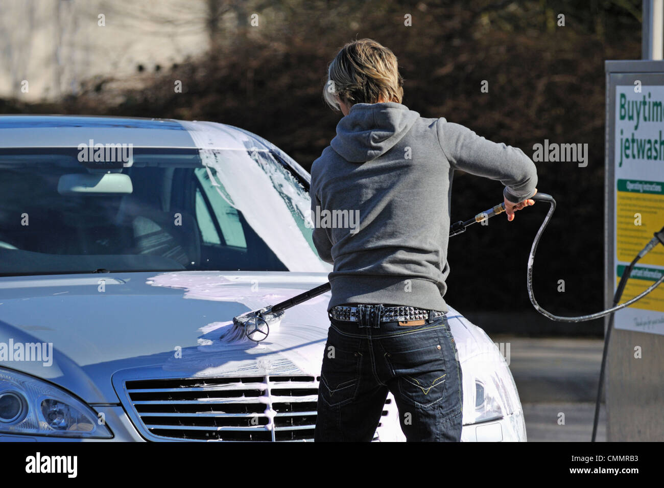 Male motorist using manual car wash. Morrisons Supermarket, Kendal