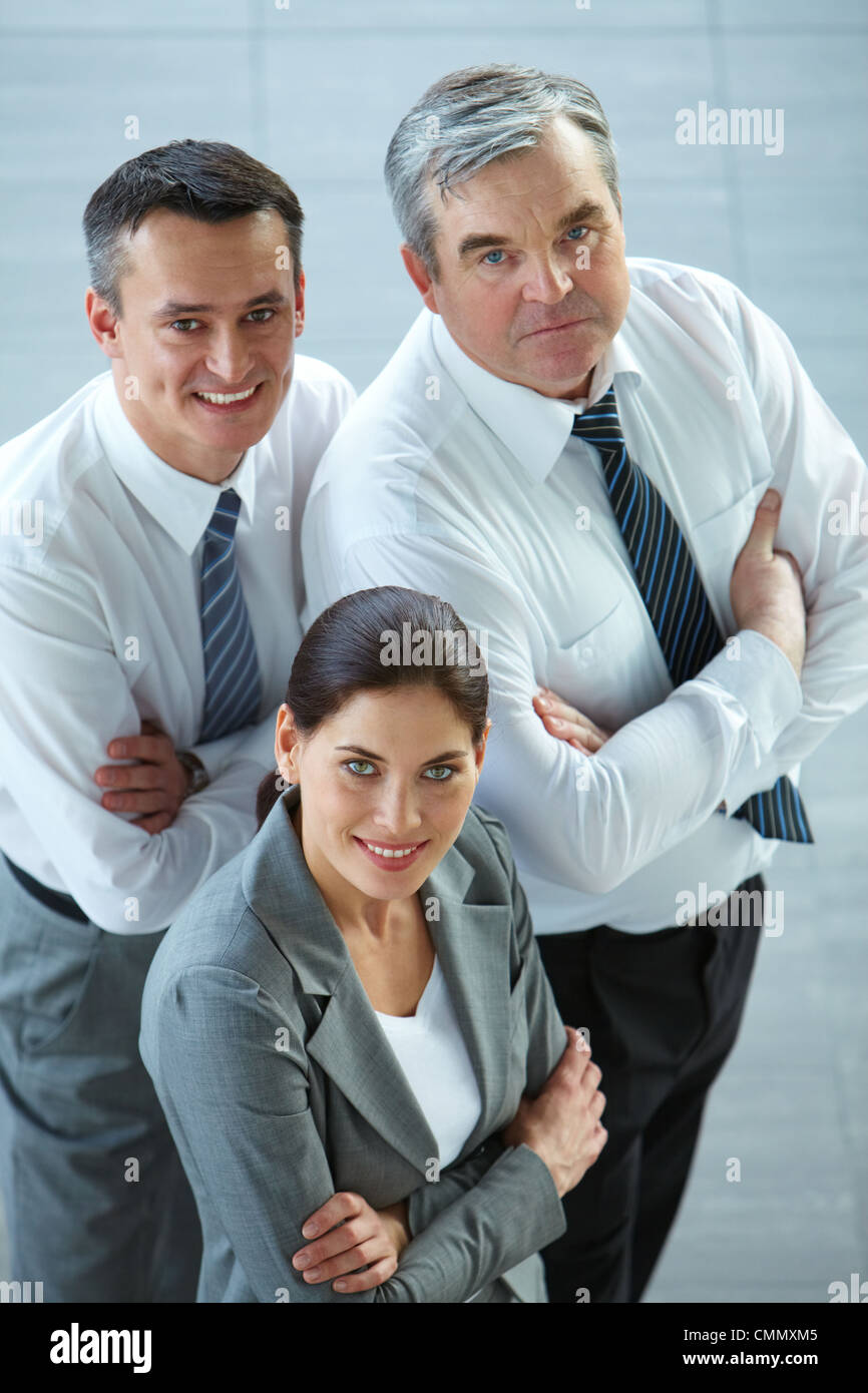 A business team with pretty leader in front looking at camera and ...
