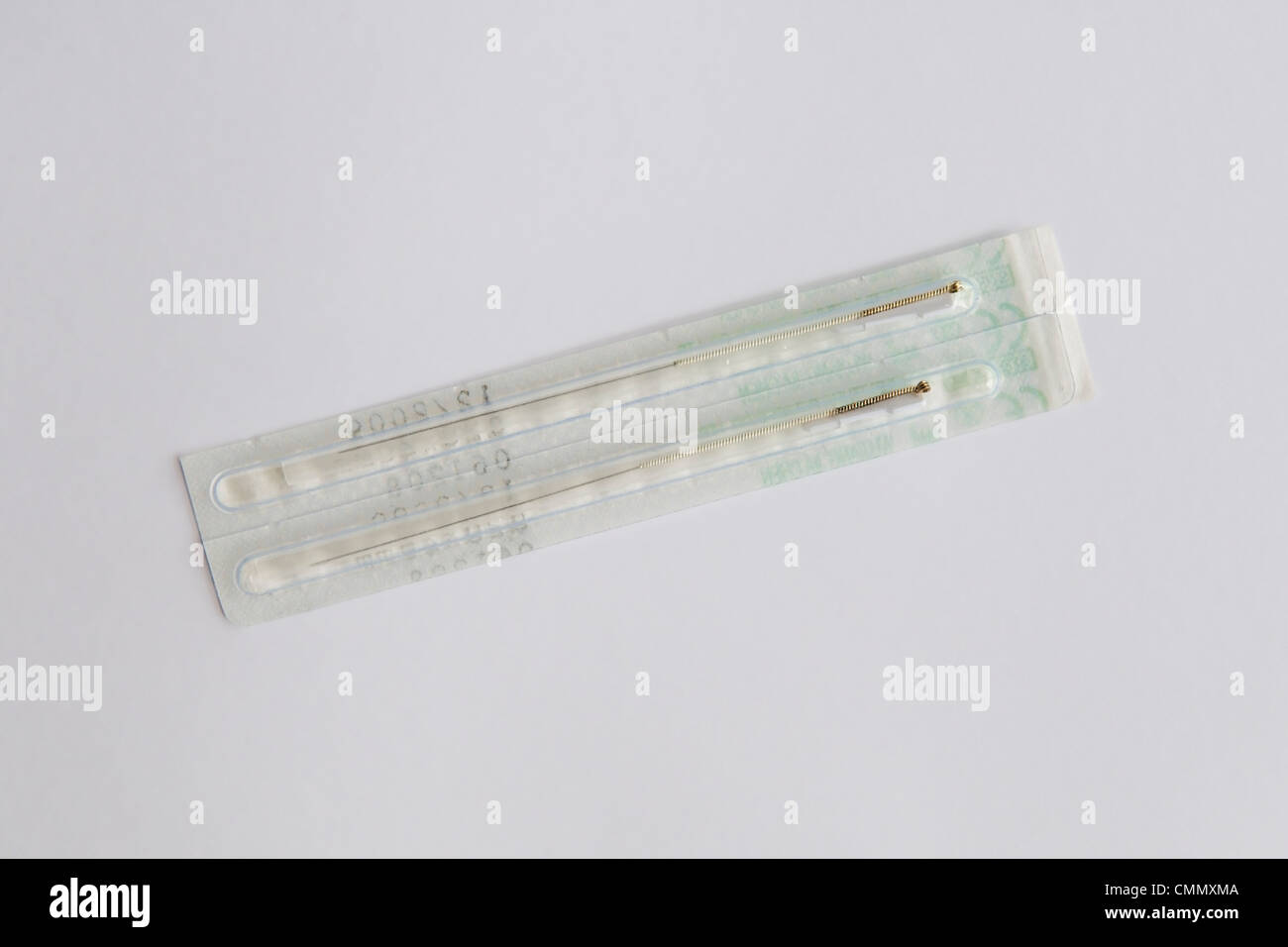 Acupuncture needles in packets taken against a plain white background Stock Photo