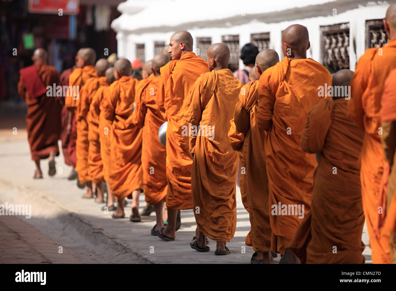 Young Buddhist monks walking around the Boddhanath stupa Kathmandu Nepal Stock Photo