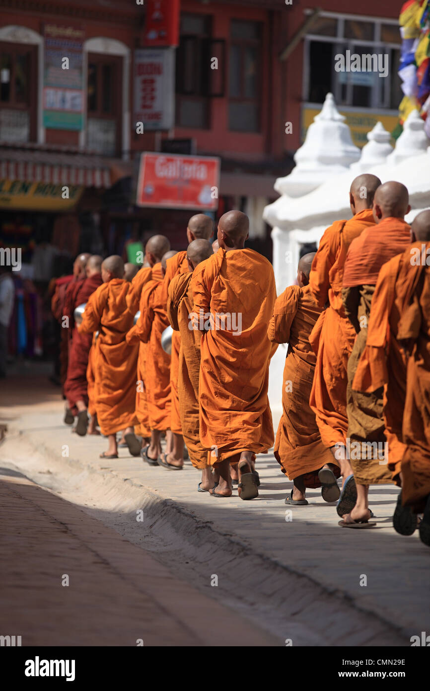 Young Buddhist monks walking around the Boddhanath stupa Kathmandu Nepal Stock Photo