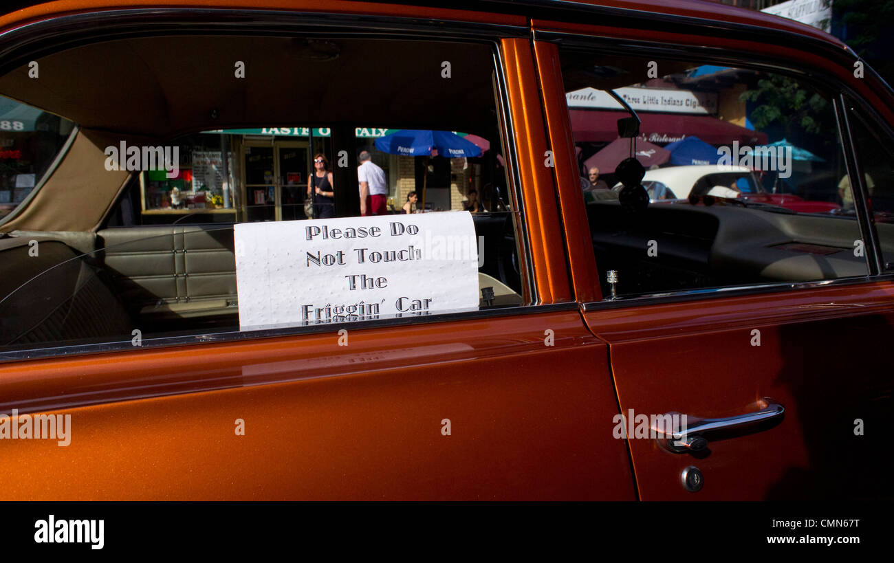 Vintage 1963 Chevy Impala parked on the street in Little Italy, New York City with a warning sign in the window. Stock Photo