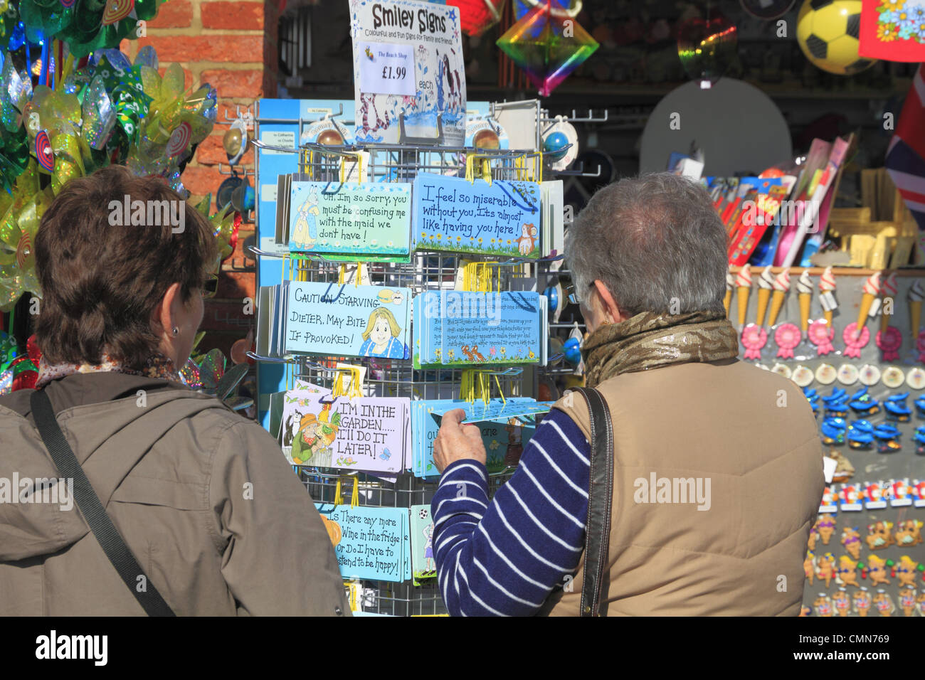 Tourists browsing the postcards and gifts at a beach front shop on