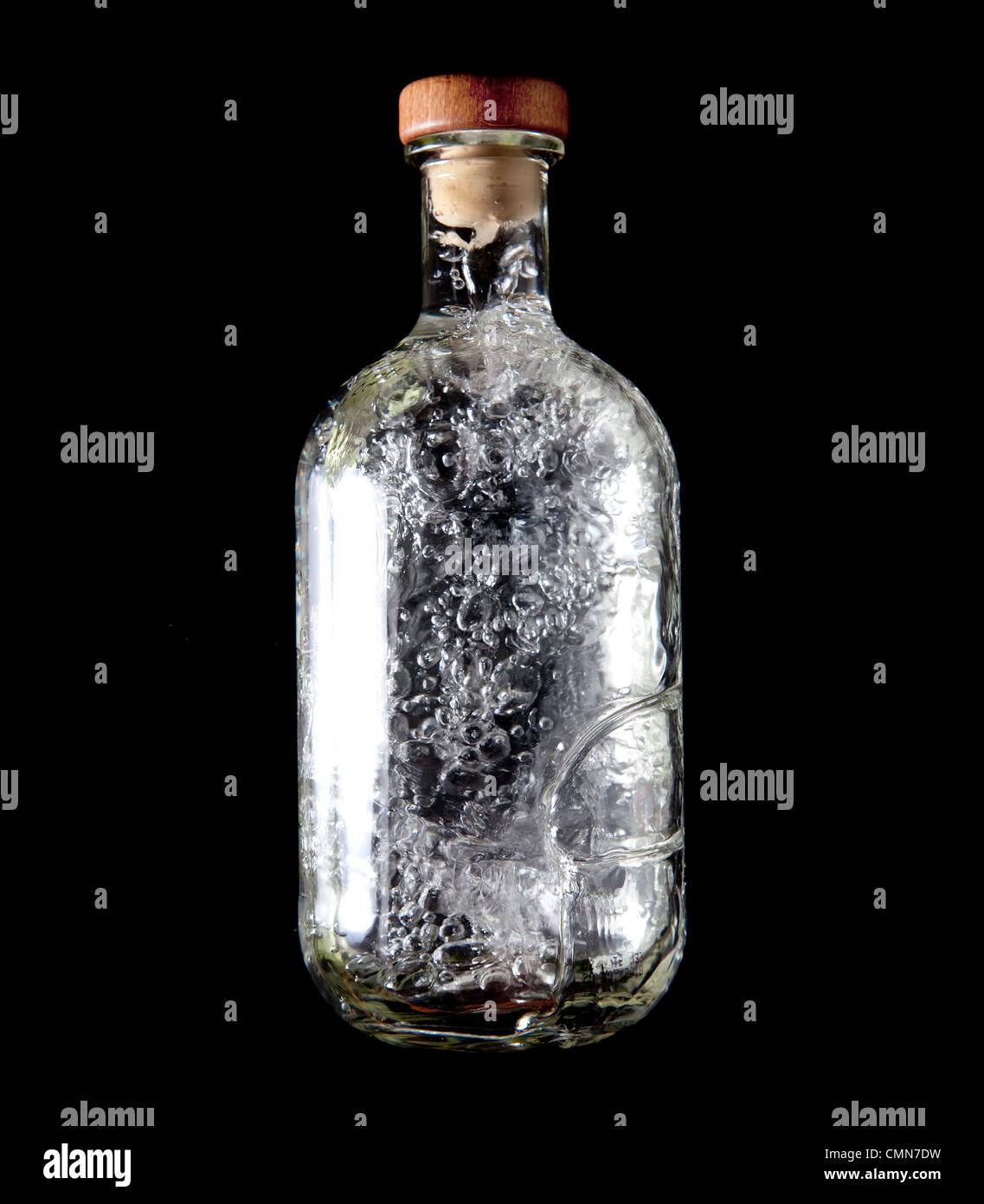 Glass bottle with cork top and bubbling liquid inside Stock Photo