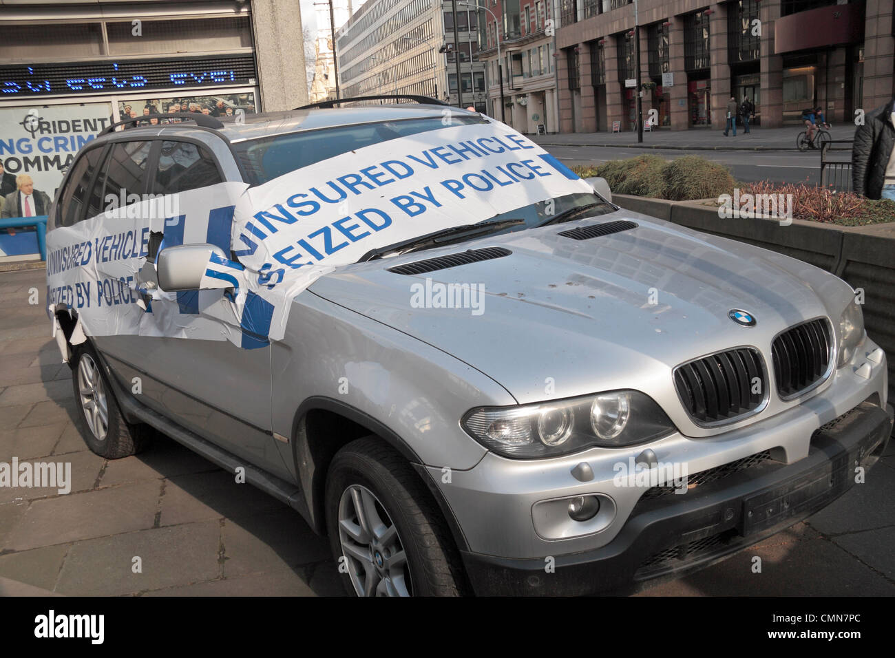 A dramatically tape-covered uninsured car seized by Police on display outside New Scotland Yard in Westminster, London, UK. Stock Photo