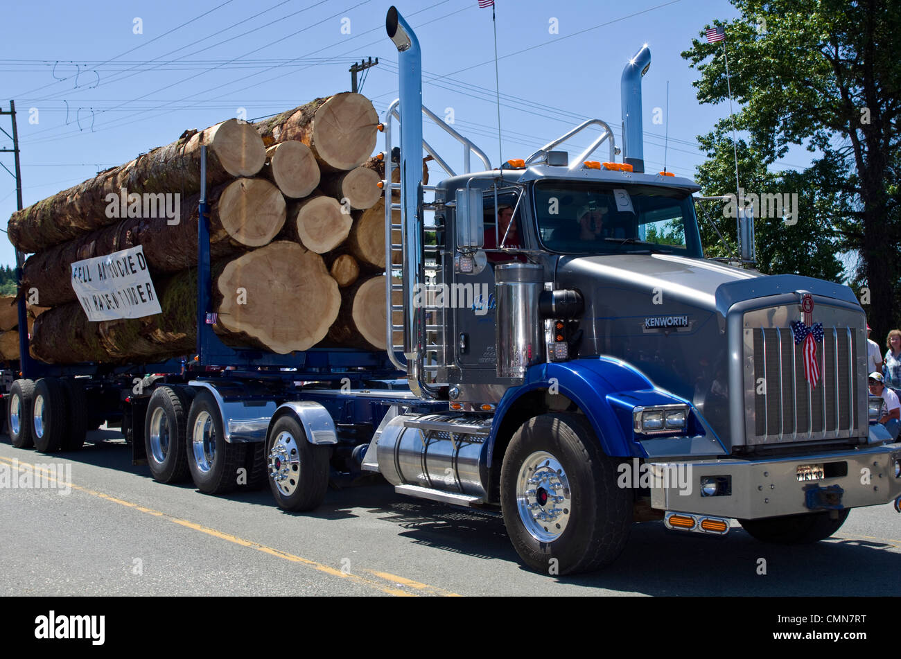 USA, Washington, Forks. Logging trucks with old growth logs in parade