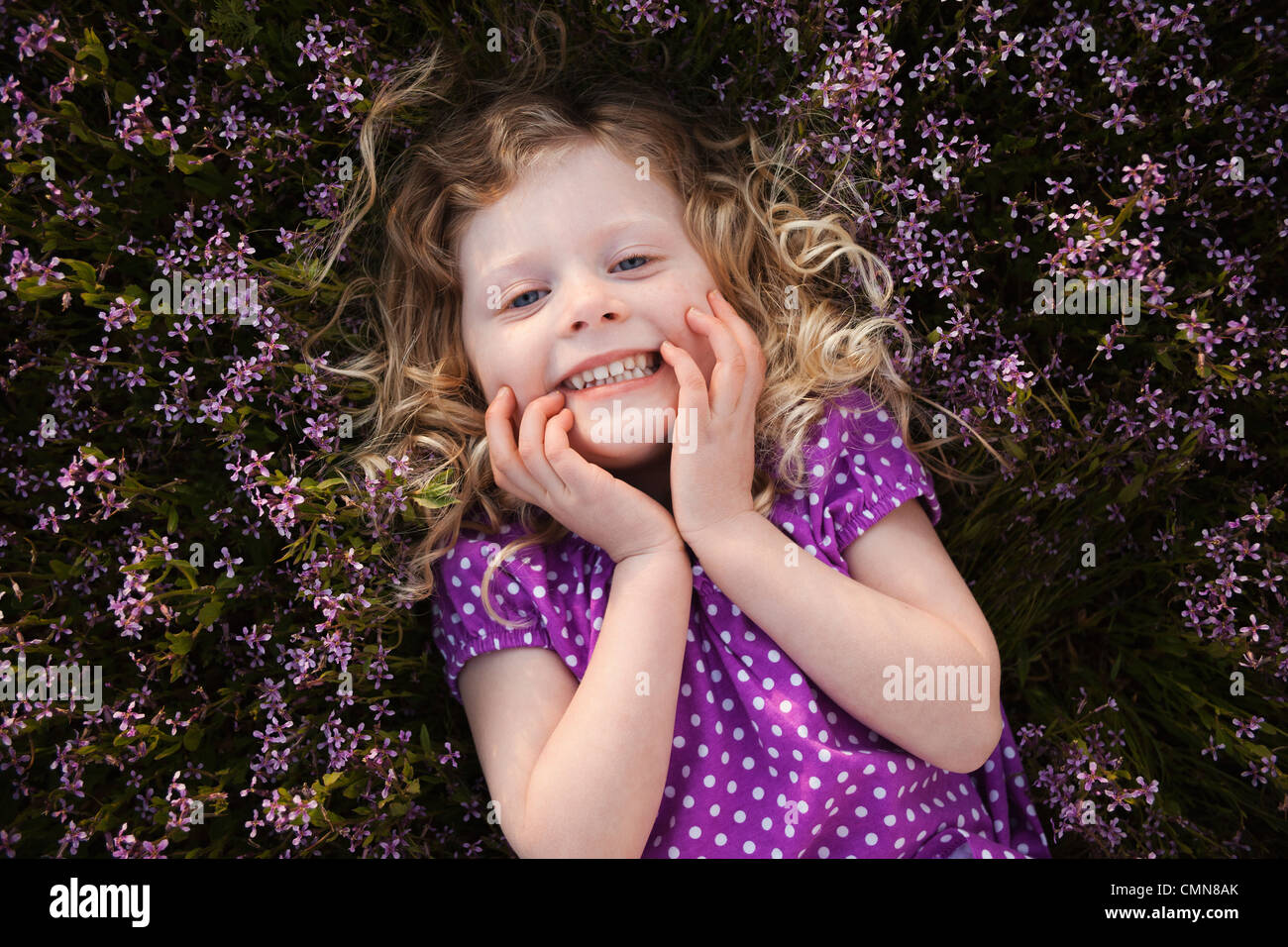 Caucasian girl laying in flowers Stock Photo
