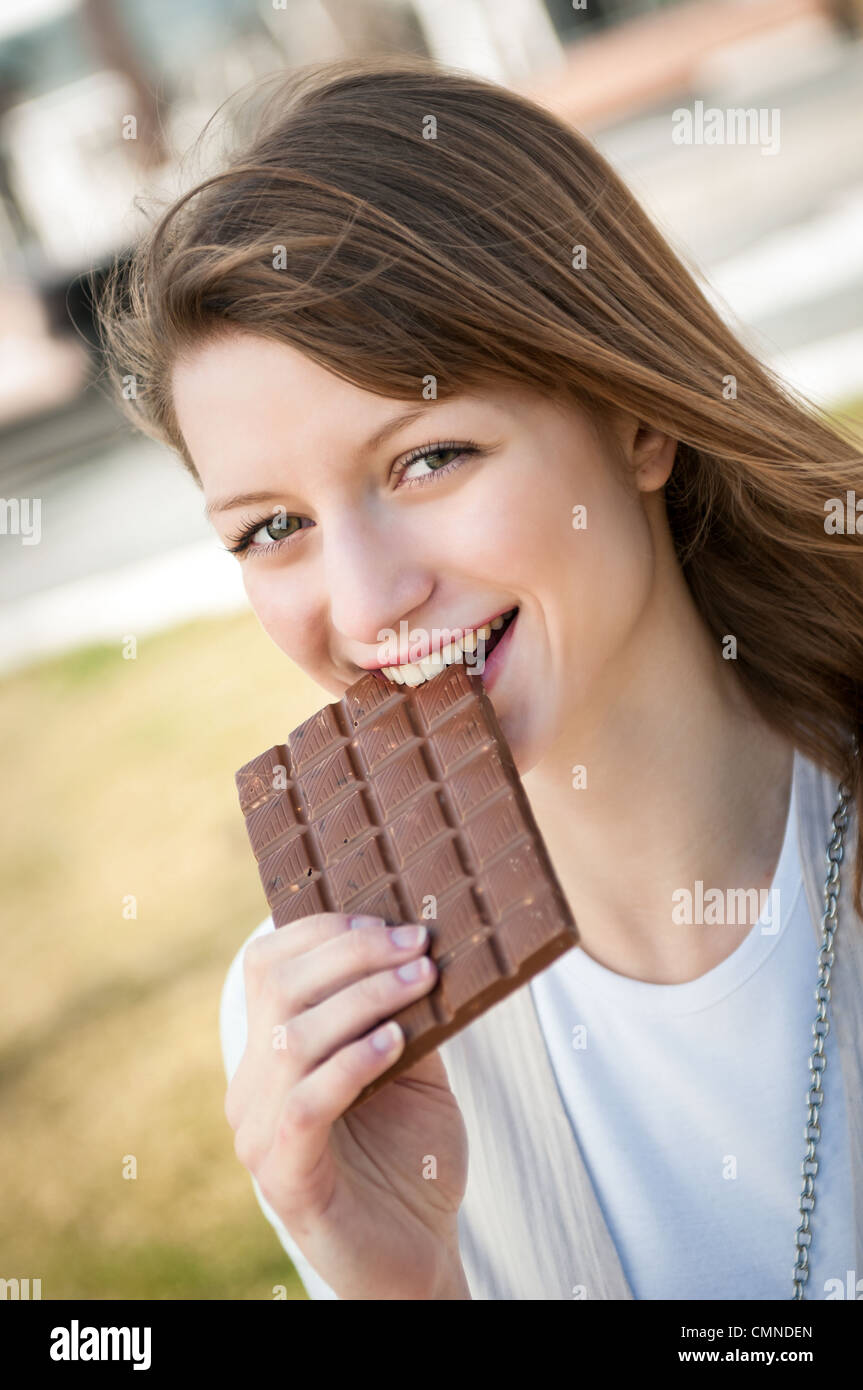 lifestyle-outdoor-scene-young-beautiful-woman-eating-chocolate-stock