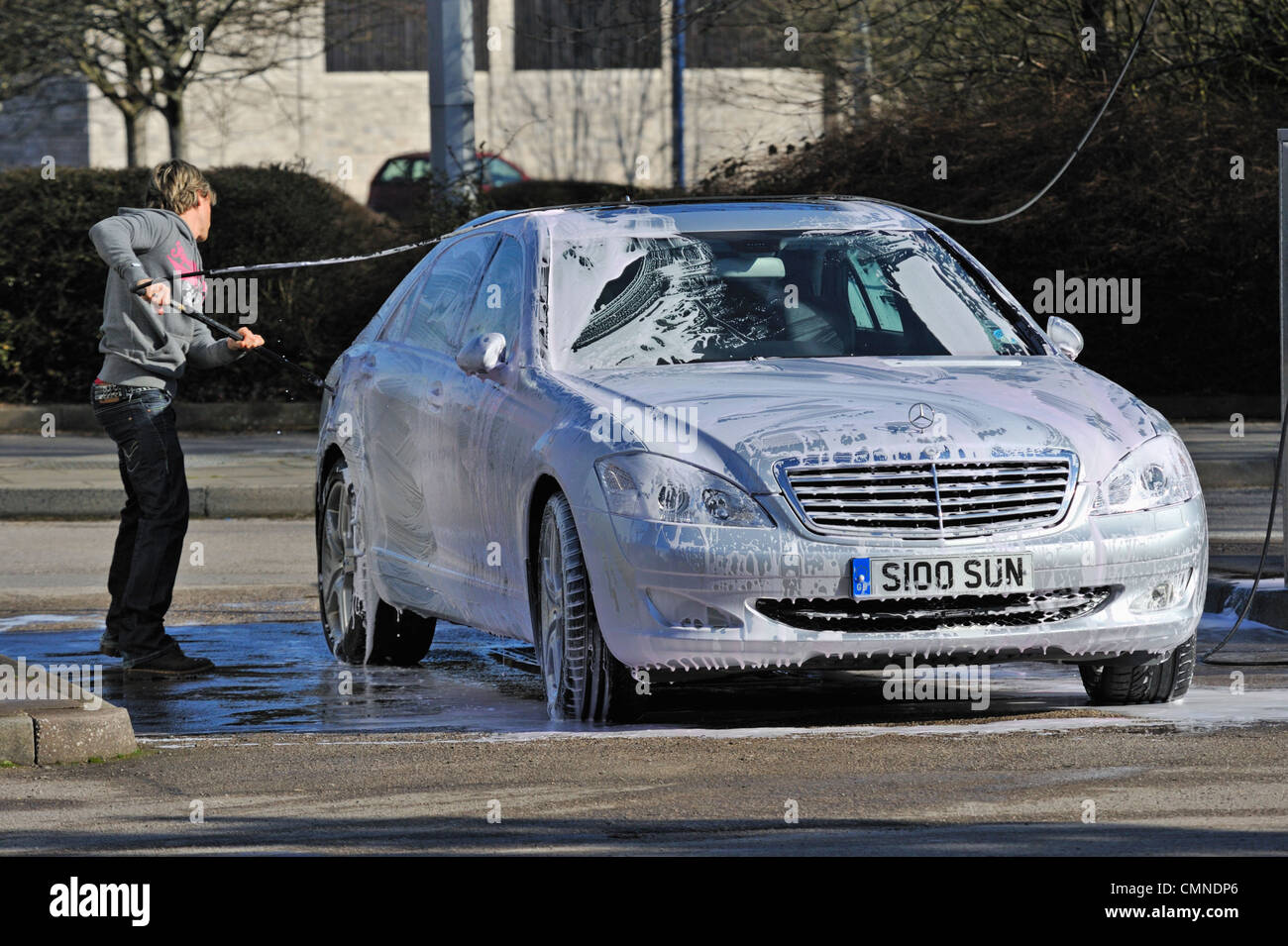 Male motorist using manual car wash. Morrisons Supermarket, Kendal