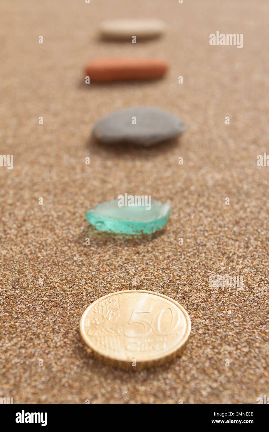 Pebbles and a gold coin indicating the path to return on investment Stock Photo