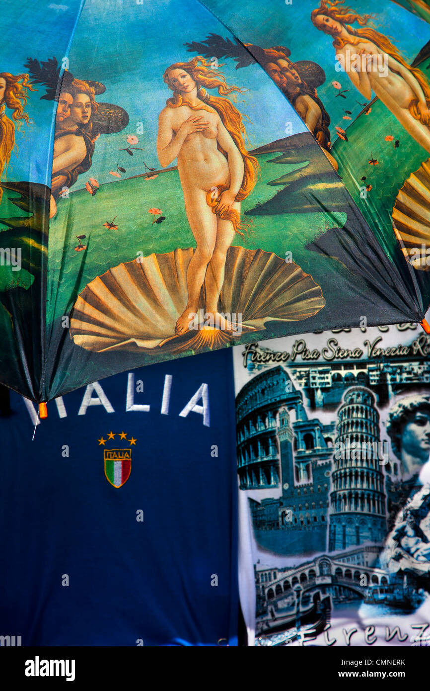 Images of the famous painting of Venus printed on umbrella alongside T-shirts on sale in a tourist stall in Florence, Italy. Stock Photo
