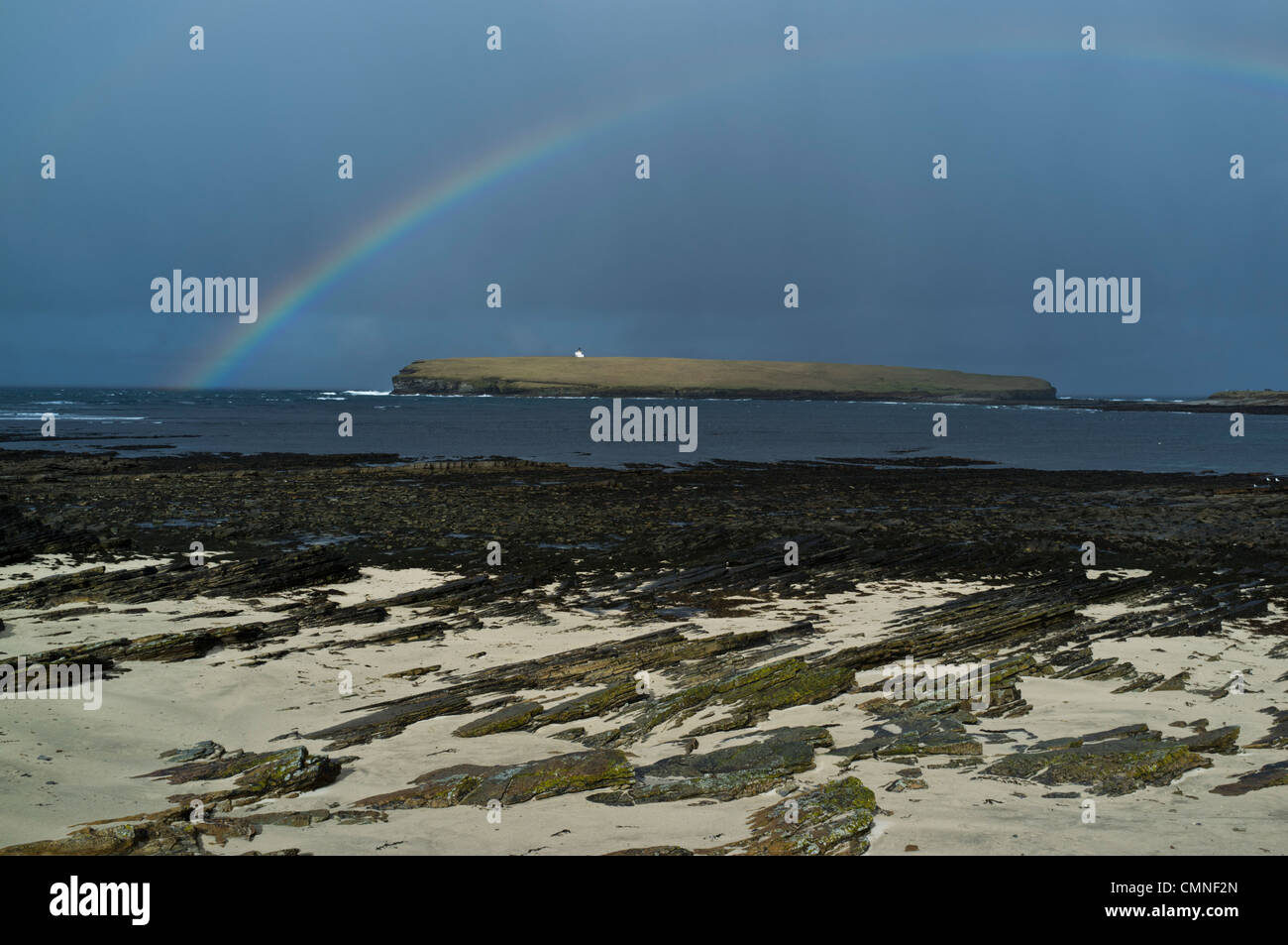 dh Brough of Birsay BIRSAY ORKNEY Scottish Rain storm clouds and rainbow Birsay coast lighthouse uk sea scotland summer Stock Photo