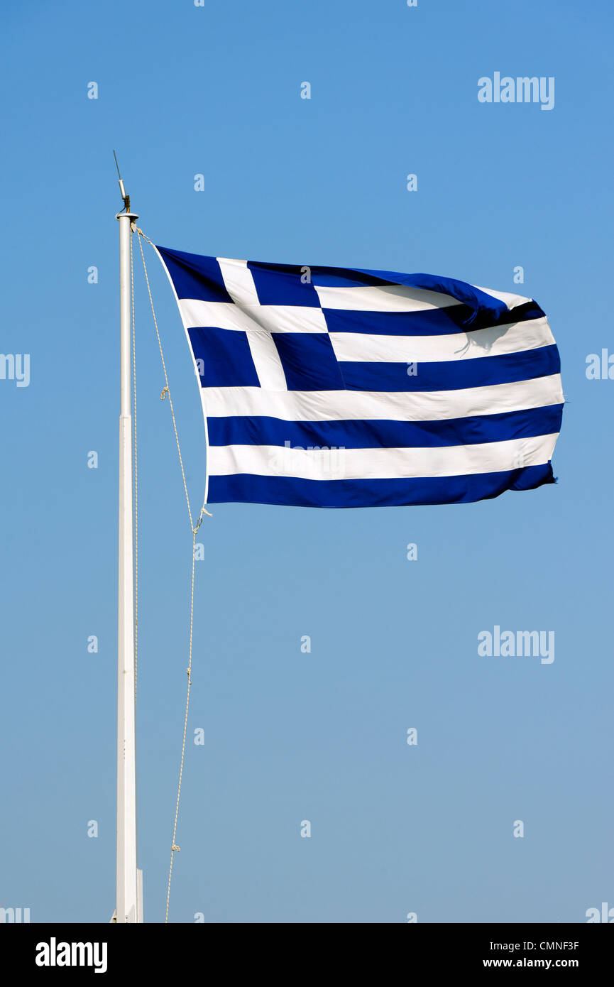 Athens. Greece. View of the national flag of Greece flying high and proudly on a flag pole against a blue sky backdrop. Stock Photo