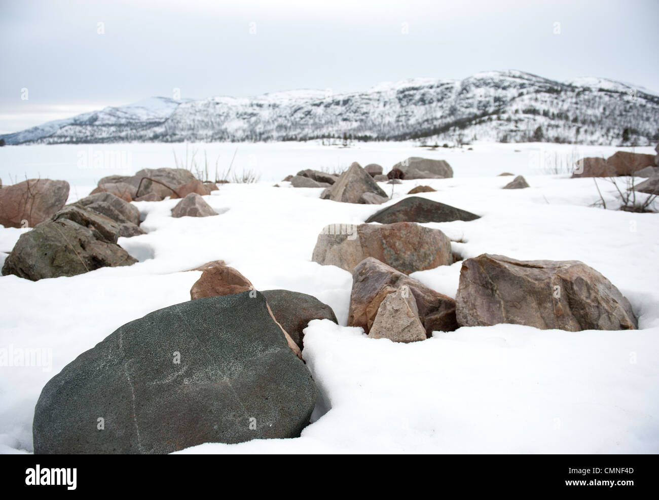 Snow-covered granite rocks at the banks of Breivevatnet, a lake near Hovden and Breive in Aust-Agder, South Norway Stock Photo