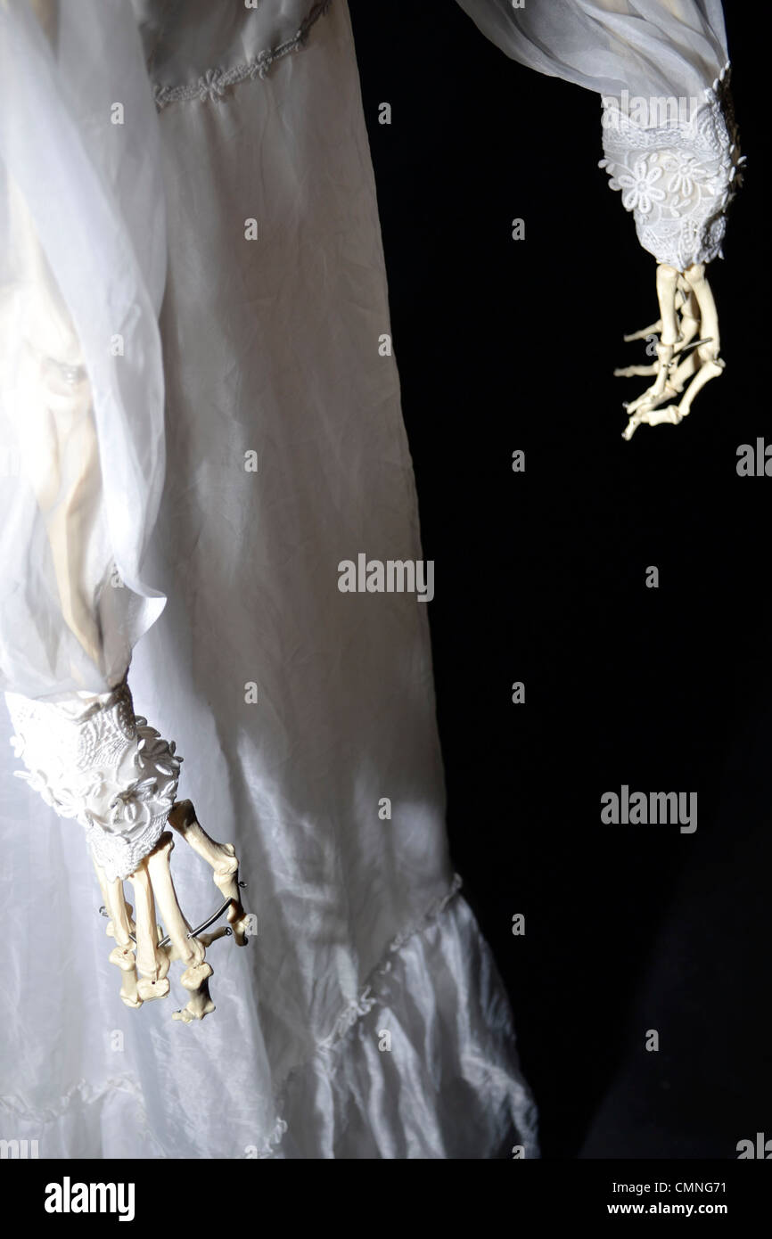 Fake Skeleton Corpse with a Secondhand Vintage Floral White Wedding Dress (Dark Studio Portrait) Stock Photo