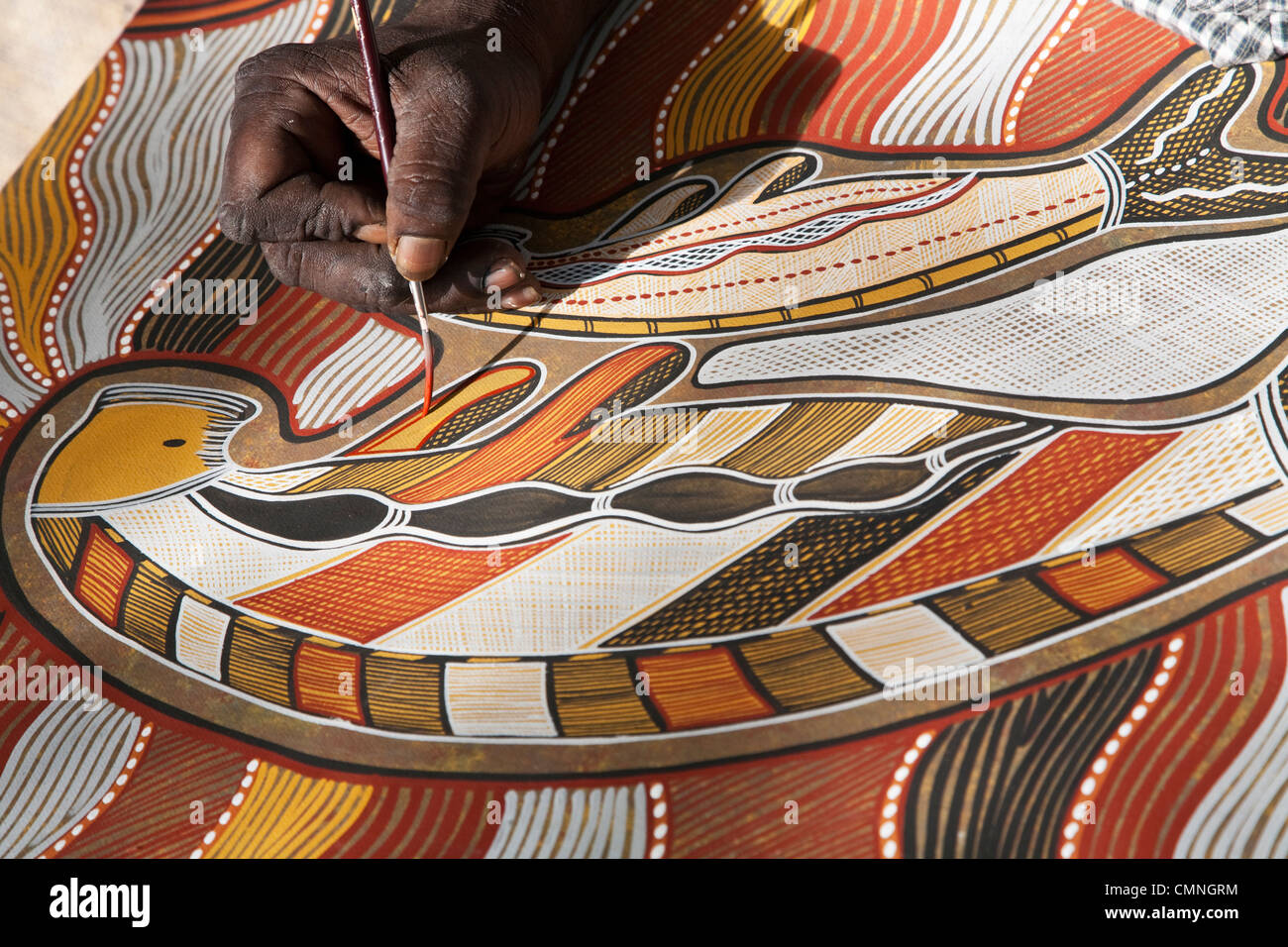 Man painting indigenous artwork of a dugong. Cooktown, Queensland, Australia Stock Photo