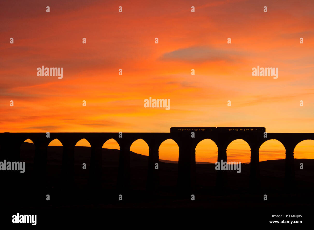 Train on the Ribblehead Viaduct on the Settle-Carlisle railway line in the Yorkshire Dales National Park, England at sunset Stock Photo