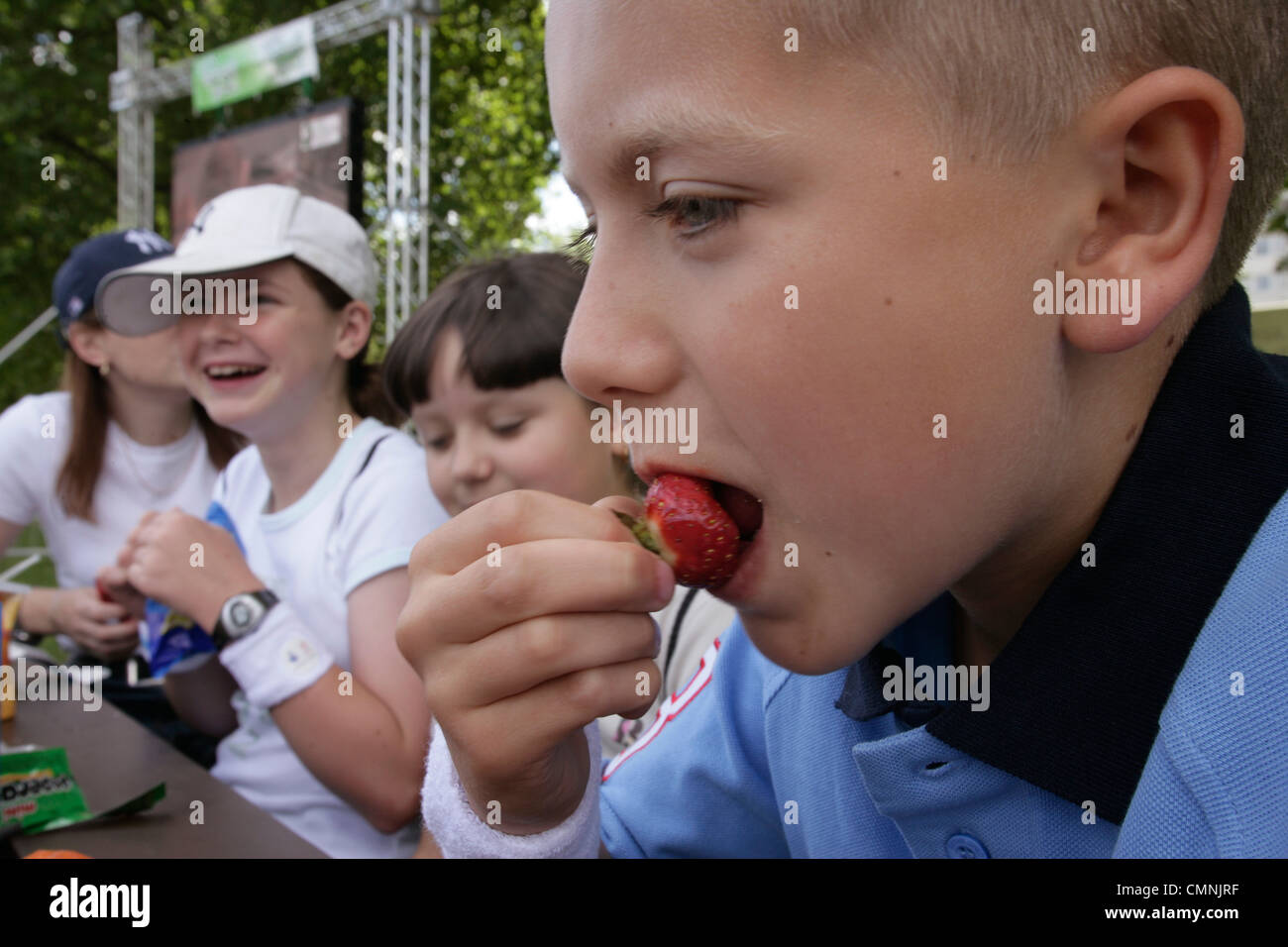 Boy eating a strawberry in Hyde Park London Stock Photo