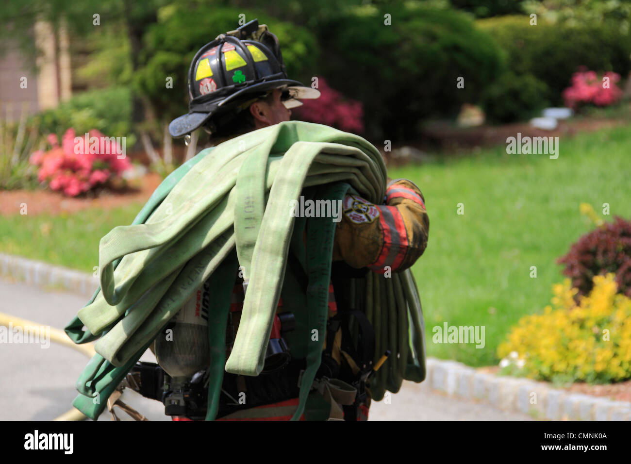 American Firefighter carrying a hose Stock Photo - Alamy