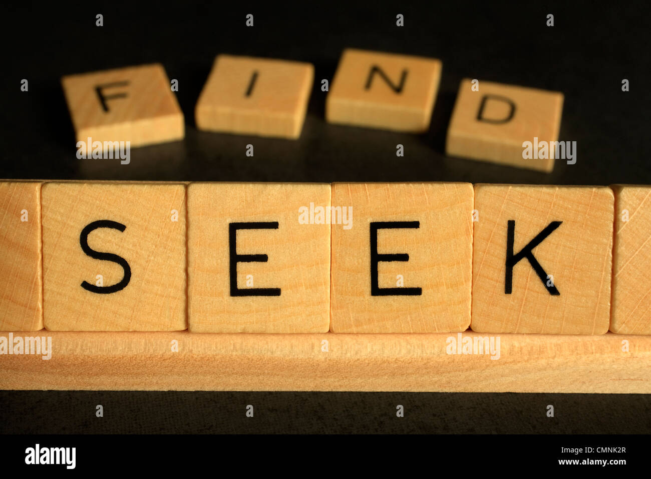 The words Seek and Find spelled out in scrabble, concepts of searching, spirituality, lost and found. Stock Photo