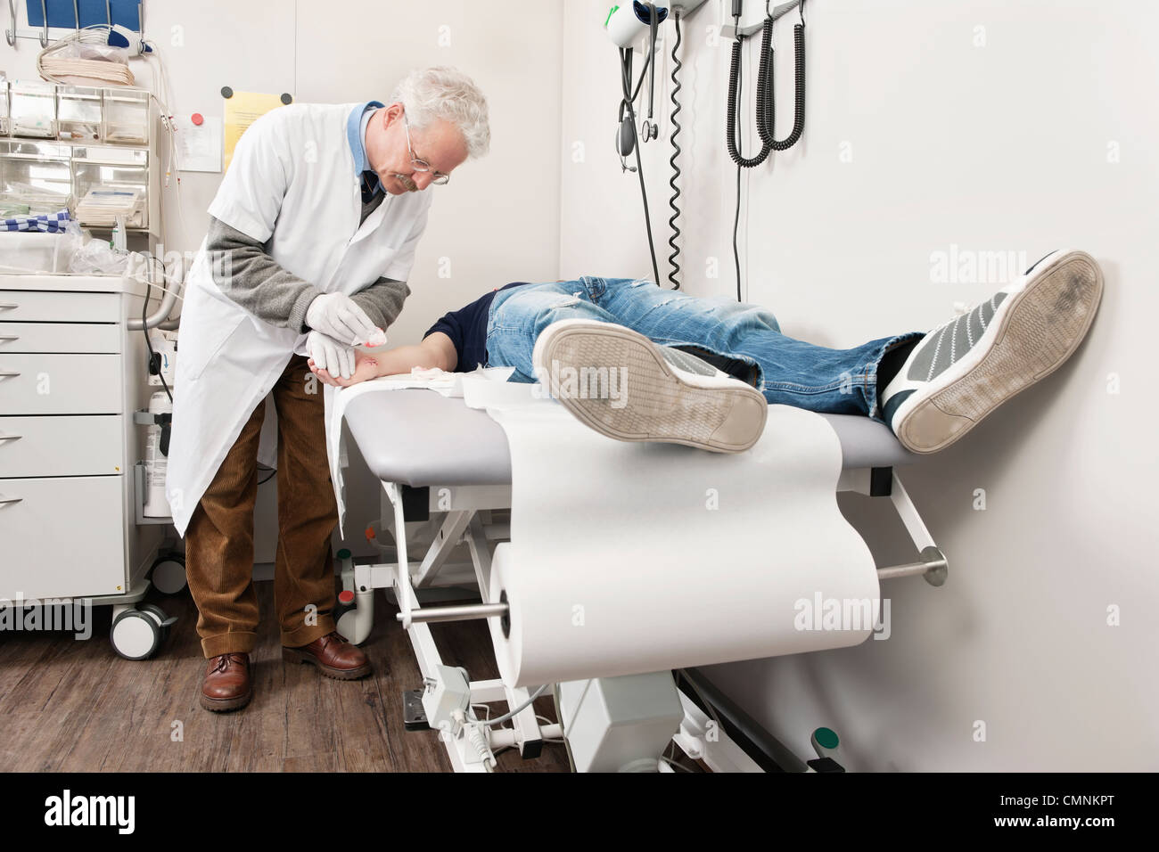 Doctor cleaning a wound in a hospital emergency medical examination room Stock Photo