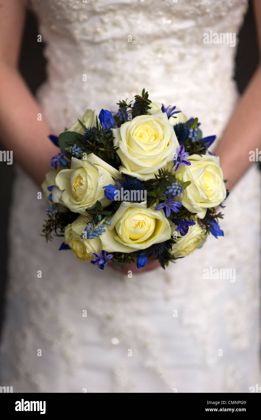 wedding bouquet of cream roses and spring flowers held by a bride Stock Photo