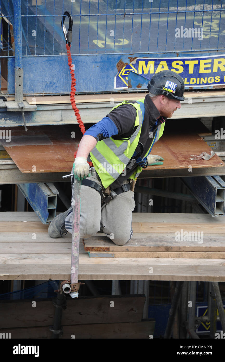 Man attached to railing with safety harness on London building site