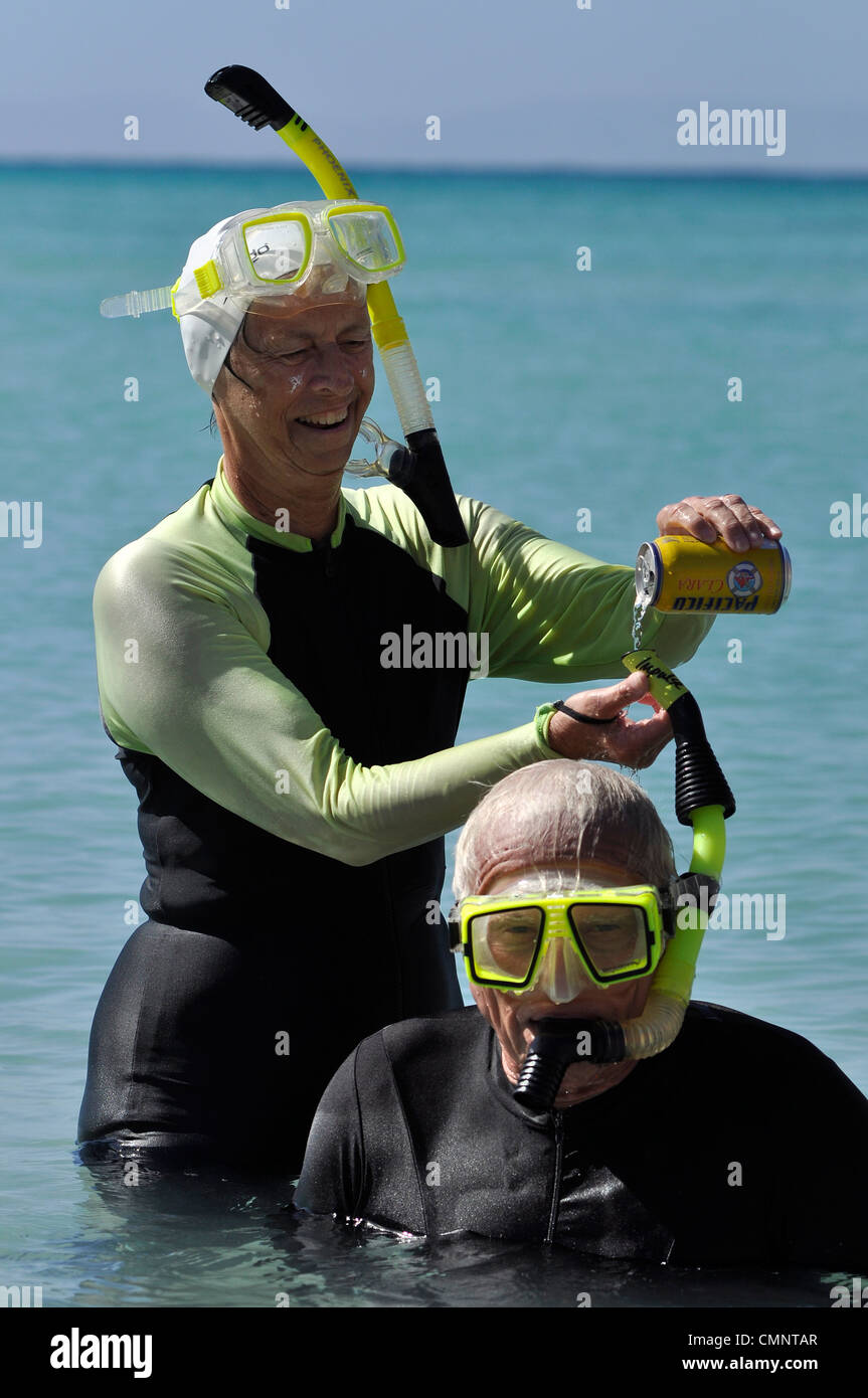 Woman pouring beer down her partner's snorkel, Sea of Cortez, Baja