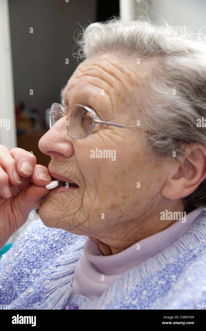 Elderly woman taking an aspirin taken for many life saving conditions