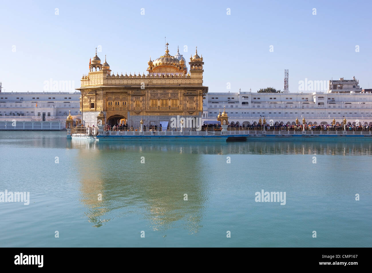 a view across the sacred pool to the golden temple at Amritsar the center of the Sikh faith Stock Photo