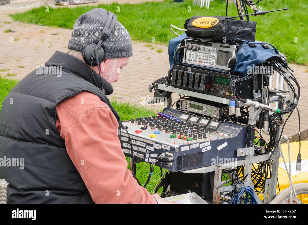 Sound engineer at a mixing desk at an outdoor film set location. Stock Photo
