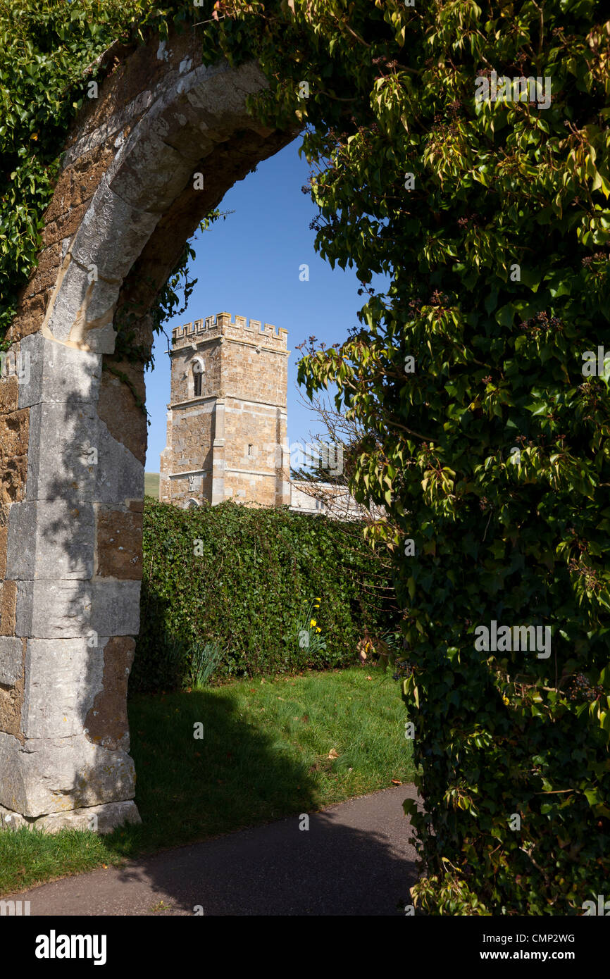 St Nicholas' Church seen through ruined archway at the former entrance to the Abbey, Abbotsbury, Dorset Stock Photo