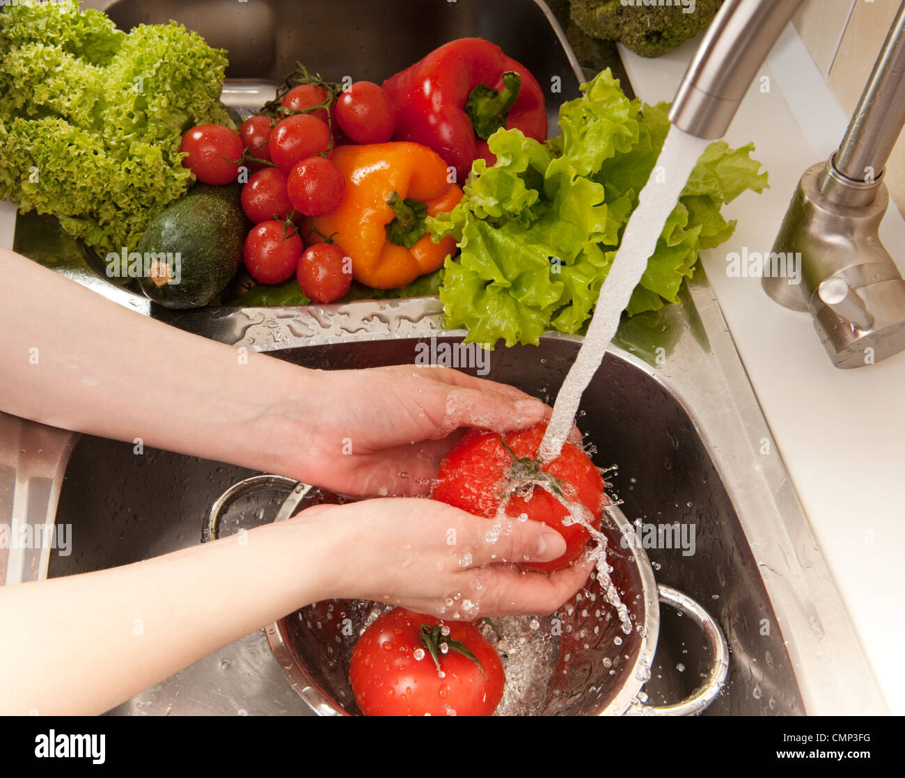 Fresh vegetables splashing in water before cooking Stock Photo