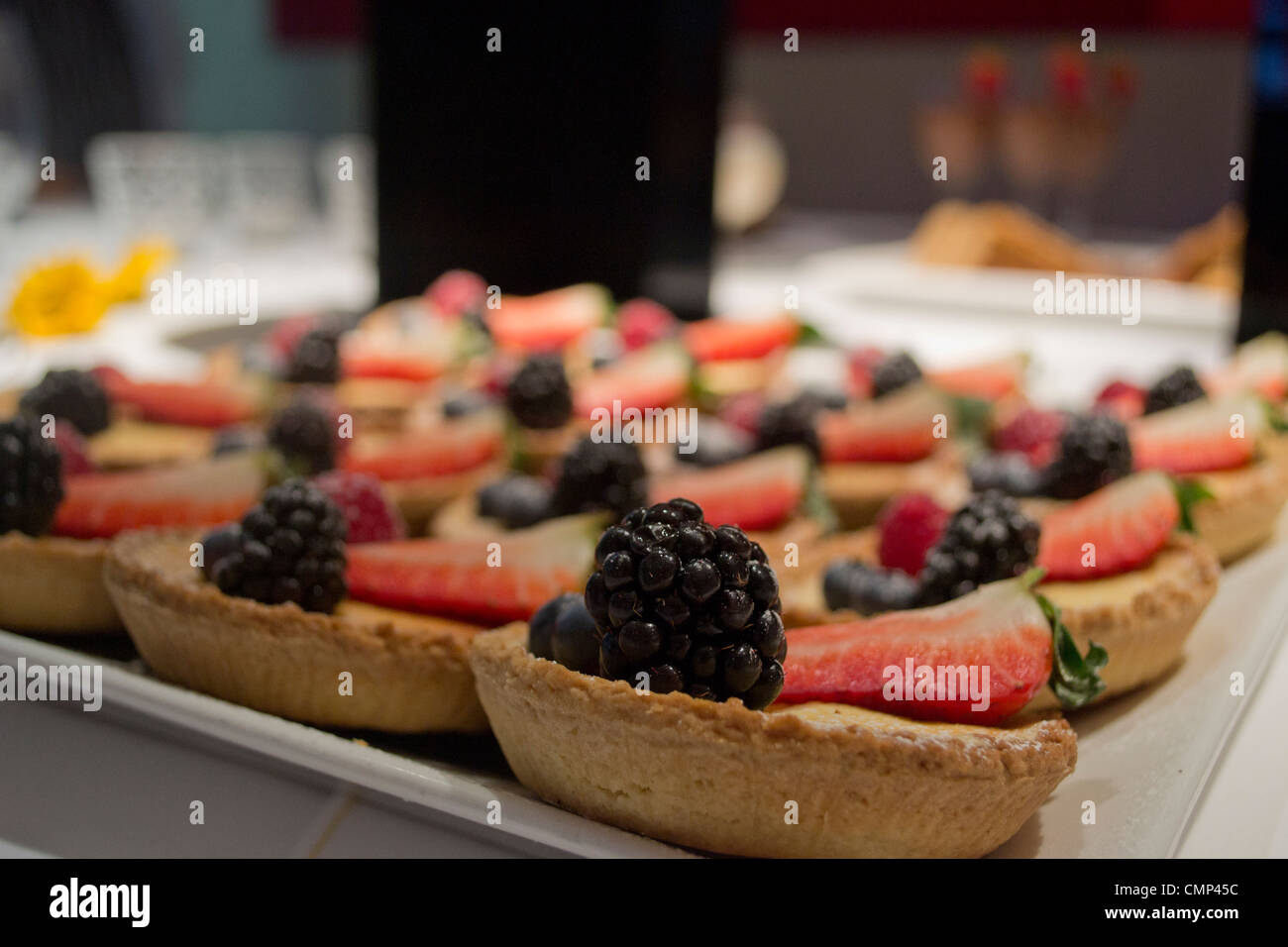 A selection of freshly-made miniature fruit tarts ready to be served at a corporate event in London. Stock Photo