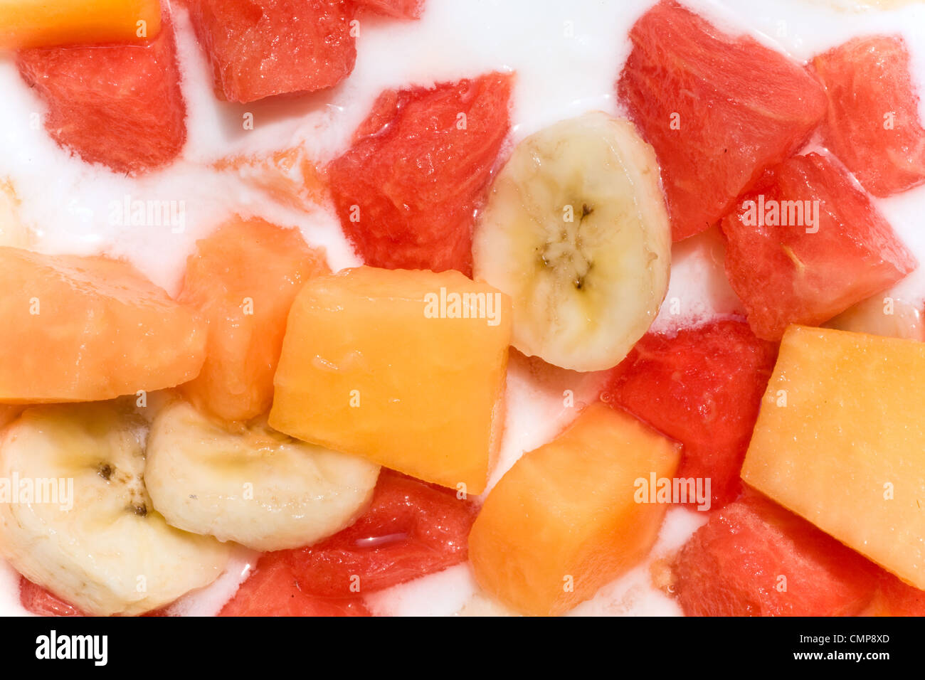 Fresh mixed fruit salad with banana, papaya,watermelon in milk Stock