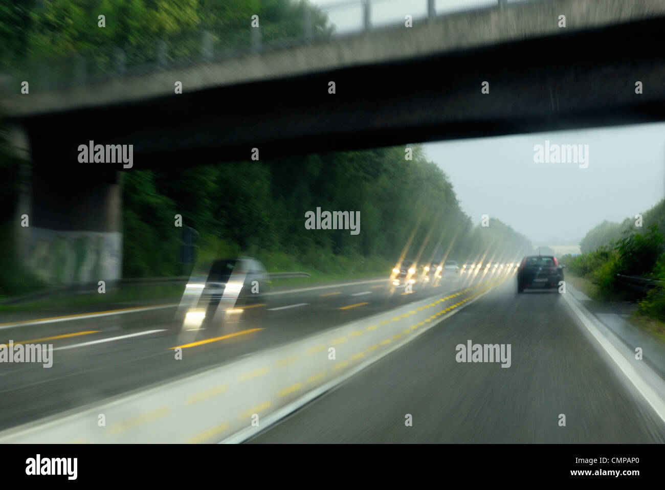 Deliberate motion blur. Driving on German autobahn motorway in Nordrhein-Westfalen near Dusseldorf and Essen on wet rainy day Stock Photo
