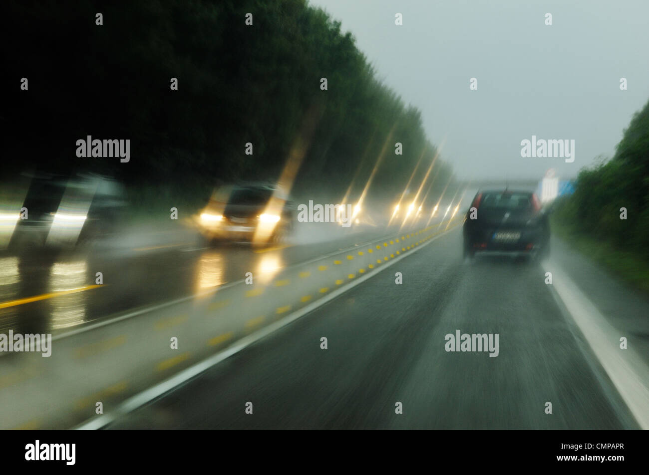 Deliberate motion blur. Driving on German autobahn motorway in Nordrhein-Westfalen near Dusseldorf and Essen on wet rainy day Stock Photo