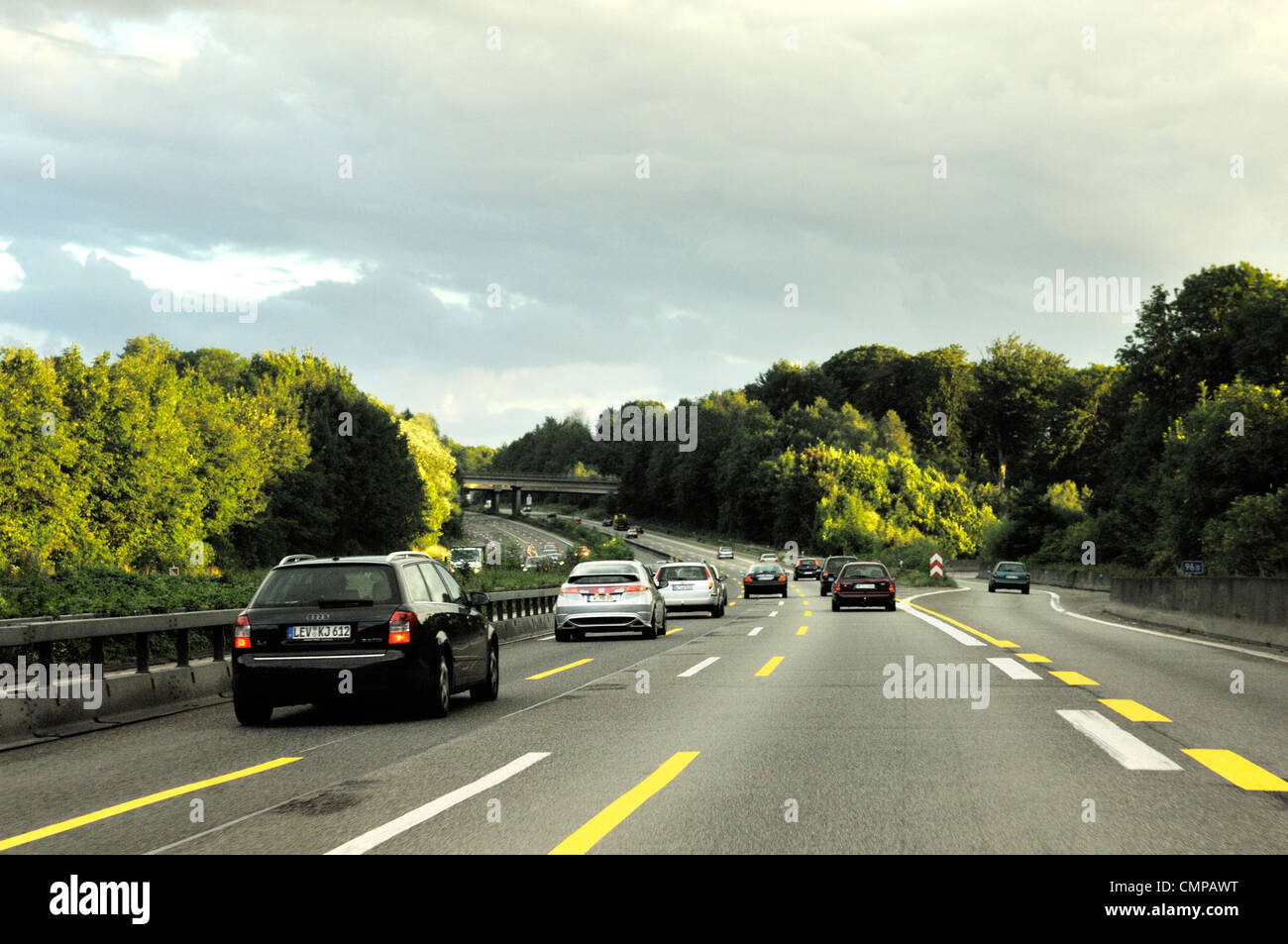 Driving on German autobahn motorway in Nordrhein-Westfalen. Turn off intersection near Dusseldorf. Evening light Stock Photo